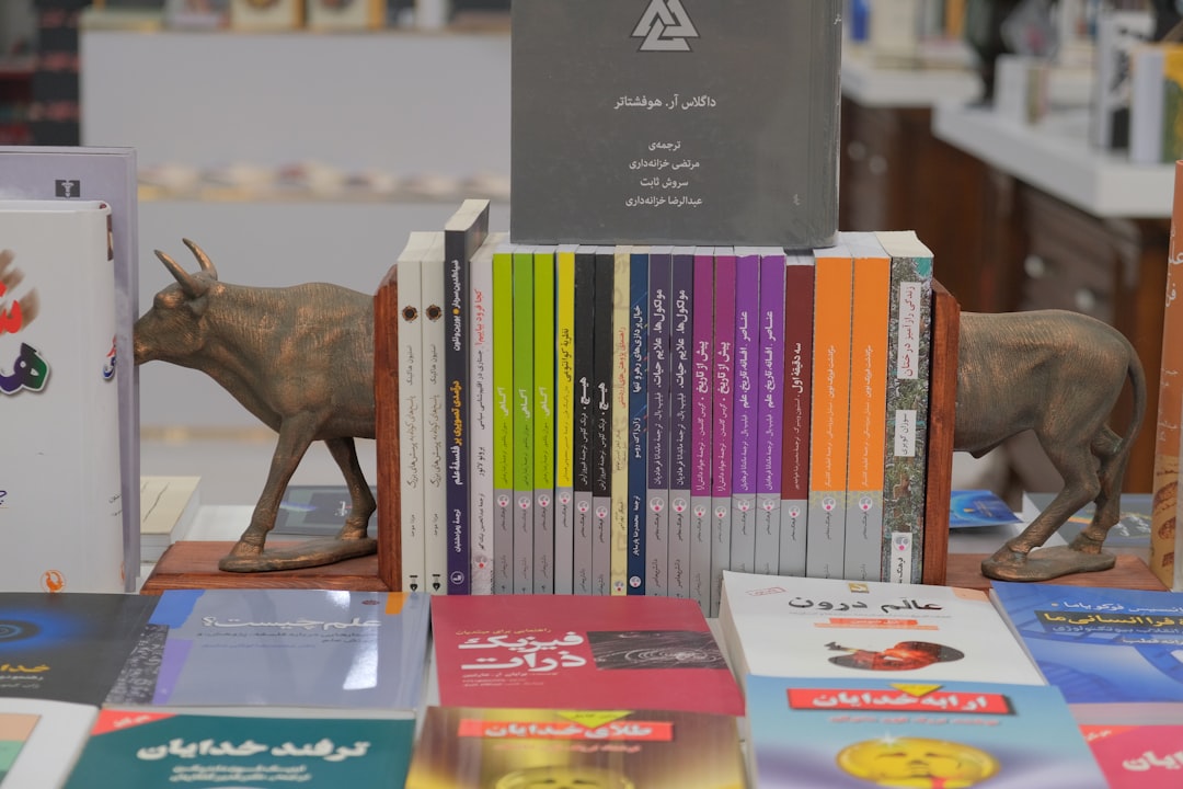 "Bookshelf with colorful books and bull-shaped bookends in a bookstore, showcasing diverse literature and reading collections."